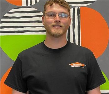 Levi (man) standing in front of green and orange mural background 