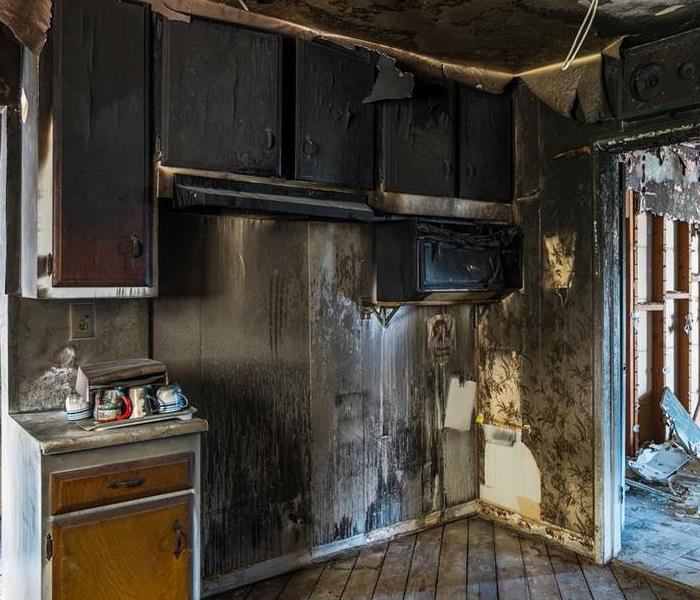 a soot covered kitchen, after a grease fire. 